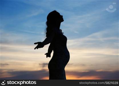 Silhouette of the cheerful pregnant woman