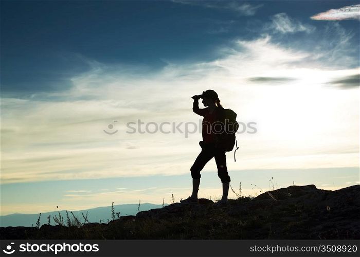 Silhouette of the girl looking in a distance against a decline
