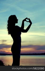 Silhouette of the lady making the heart sign