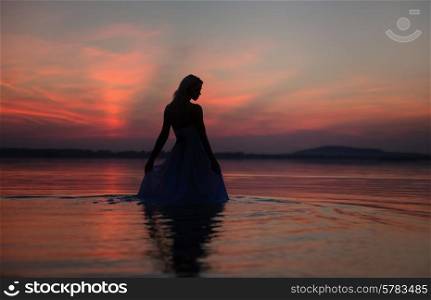 Silhouette of the lady over the sunset background