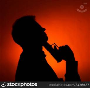 silhouette of the man pointing gun to his head, ready to commit suicide