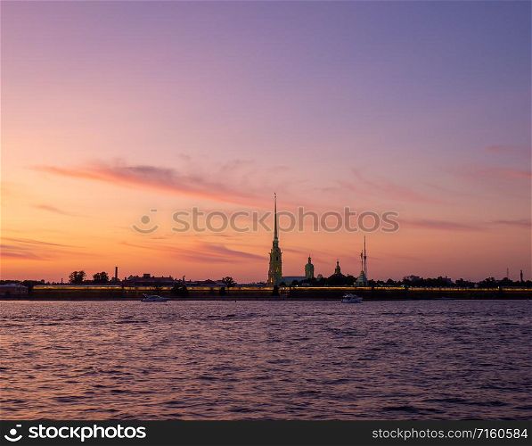 Silhouette of the Peter and Paul Fortress against the setting sun. Peter and Paul Fortress against the backdrop of a crimson sky