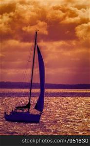 Silhouette of the sailing boat at sunset