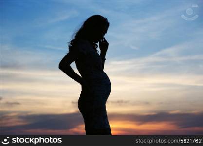 Silhouette of the young pregnant woman