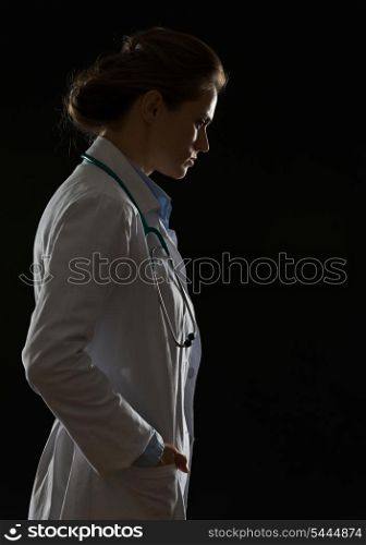 Silhouette of thoughtful doctor woman isolated on black