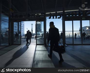 silhouette of travellers in modern surroudings of railway station entrance in city of utrecht in the netherlands