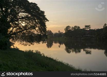 Silhouette of trees at riverside at sunset, Chiang Rai, Thailand