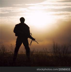 Silhouette of US marine with rifle against the sunset