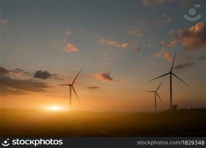 Silhouette of wind turbines. Beautiful view of wind generators in the mountain hill at sunset.