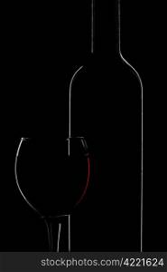silhouette of wine bottle and glass isolated over black