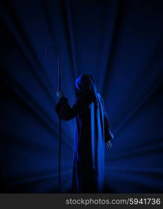 Silhouette of witch on blue rays background