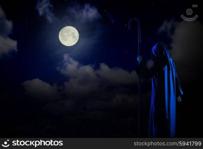 Silhouette of witch on night sky background