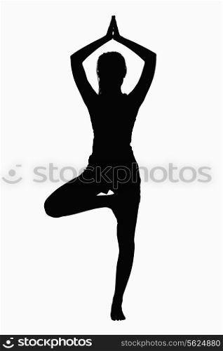 Silhouette of woman doing yoga pose.