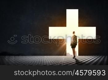 Silhouette of woman in cross. Businesswoman standing with back in light of cross door