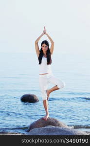 Silhouette of woman in yoga lotus meditation position front to seaside