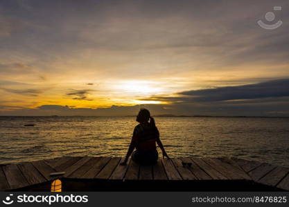 silhouette of woman jumπng on the sea at sunset. soft focus and low key