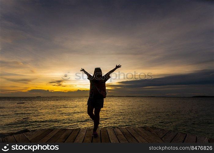 silhouette of woman jumping on the sea at sunset. soft focus and low key