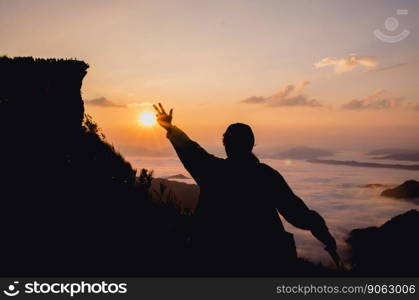 silhouette of woman standing on hill is hand up in the air