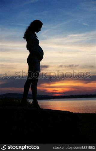 Silhouette of woman touching her belly