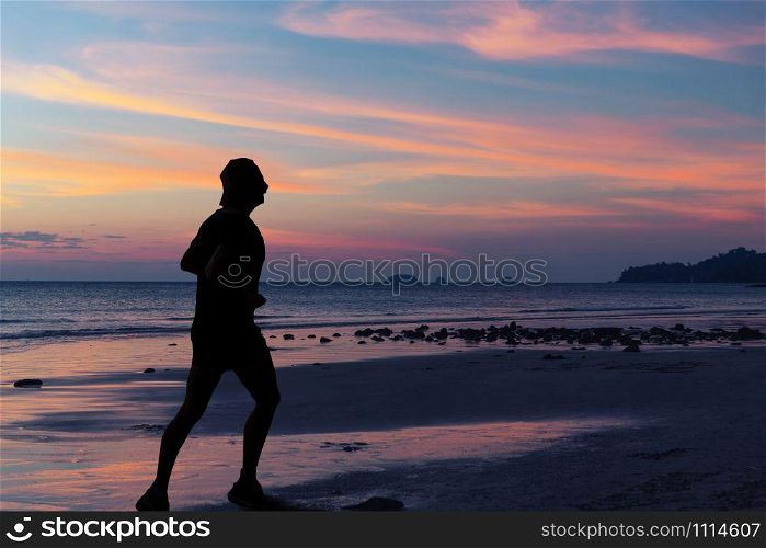 silhouette of woman walking along the sea coast