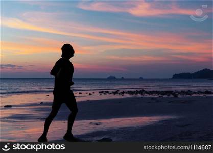 silhouette of woman walking along the sea coast