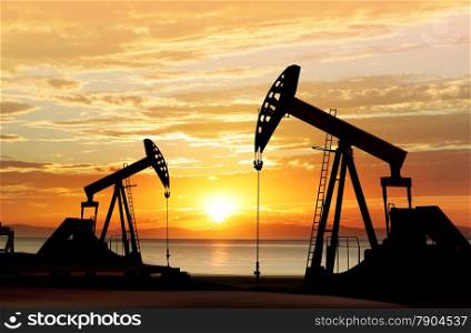 silhouette of working oil pumps on sunset background