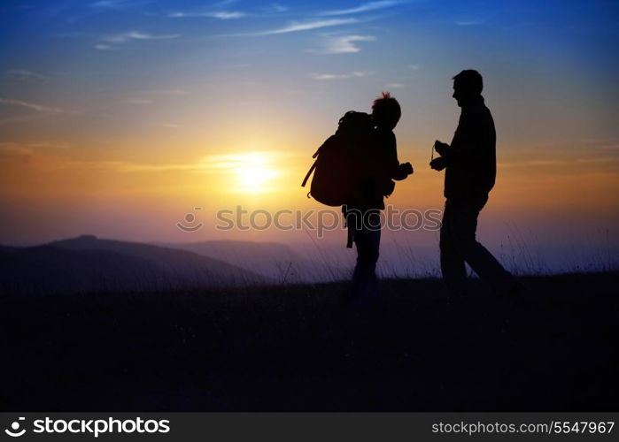 Silhouette of young couple against colorful sunset