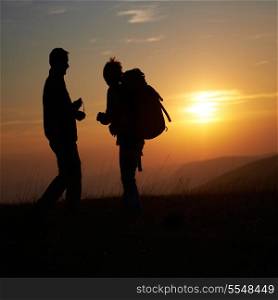 Silhouette of young couple against orange sunset
