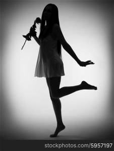Silhouette of young girl with rose flower on gray background (monochrome)