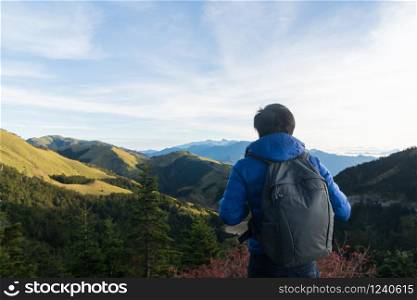 Silhouette of young man enjoying the amazing view on top of mountain