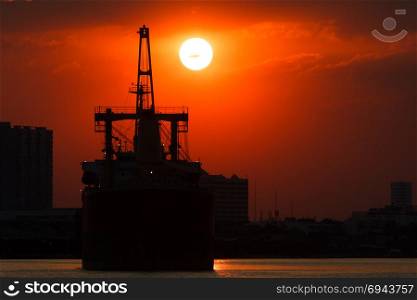 Silhouette picture of vessel with sunset in background.