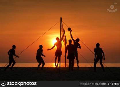 silhouette play beach volleyball. Sunset time