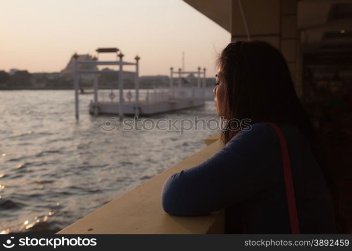 Silhouette portrait woman near river. reflective sunlight in water river.