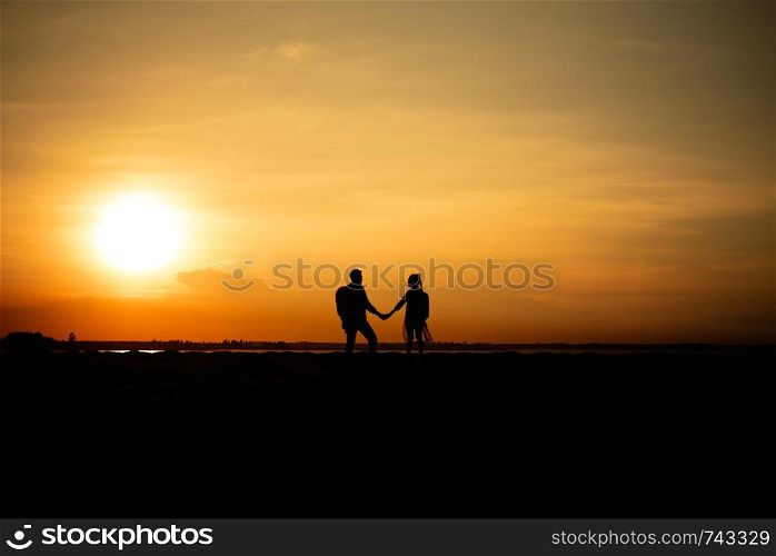 Silhouette traveler couples walking on mountain at sunset times. Silhouette traveler couples walking