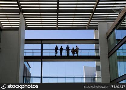 Silhouette view of some people in a modern office building interior with panoramic windows.