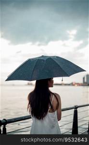 Silhouette  woman holding umbrella in the rain at sea, selective focus . Silhouette  woman holding umbrella in the rain at sea