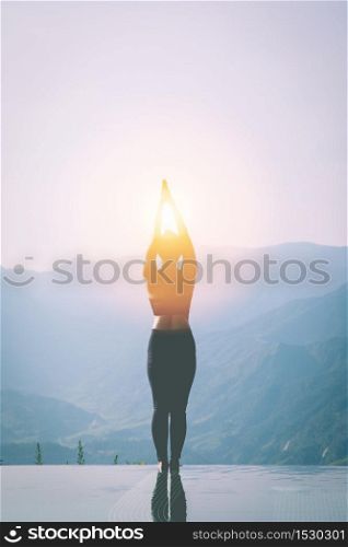 silhouette woman practice yoga Surya Namaskar exercise Ekam pose on the pool above the Mountain peak in the morning in front of beautiful nature views in SAPA vietnam,Feel comfortable