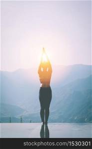 silhouette woman practice yoga Surya Namaskar exercise Ekam pose on the pool above the Mountain peak in the morning in front of beautiful nature views in SAPA vietnam,Feel comfortable