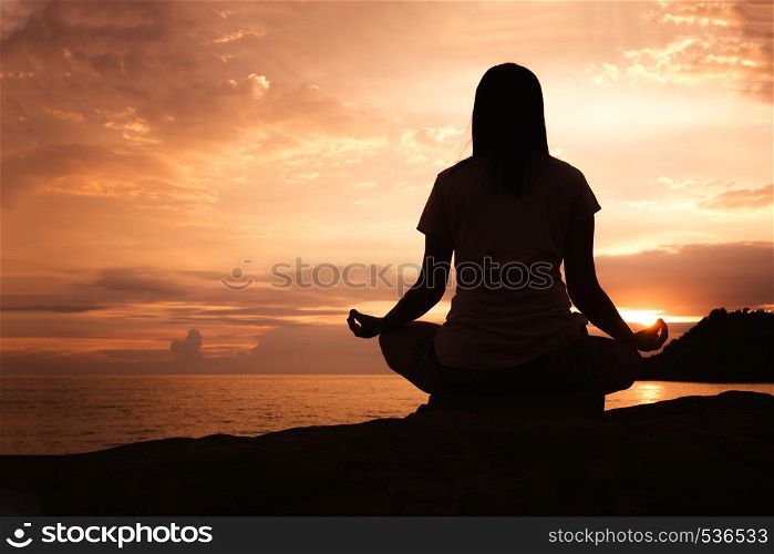 Silhouette young asian woman practicing yoga pose at beach,concept for Yoga Sport and Healthy lifestyle