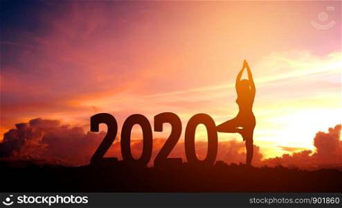 Silhouette young woman practicing yoga on 2020 new year