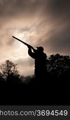 silhouetted hunter with gun