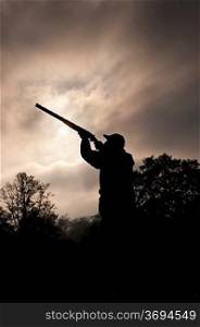 silhouetted hunter with gun