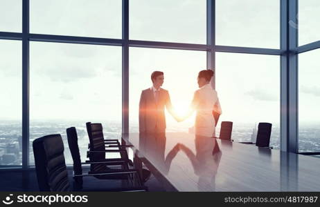 Silhouettes of Business People in Office. Mixed media. Two business people in office in lights of sunset