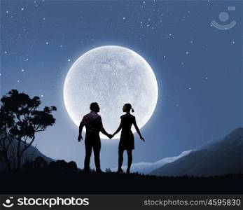 Silhouettes of couple against big moon at background