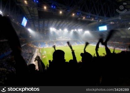 Silhouettes of fans celebrating a goal on football / soccer match