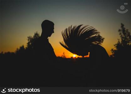 Silhouettes of happy couple jumping with raised arms near lake at sunset. couple near the sunset, people, craazy. Silhouettes of happy couple jumping with raised arms near lake at sunset. couple near the sunset, people, craazy.