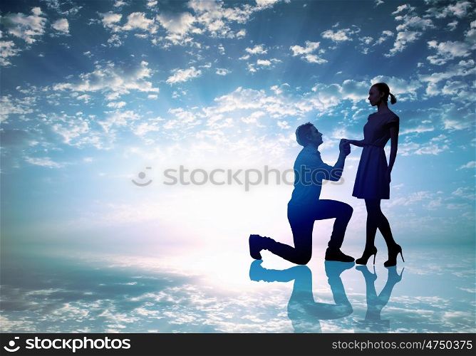 Silhouettes of man making proposal to woman
