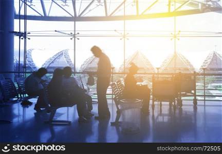 Silhouettes of passengers at airport hall. People in motion blur