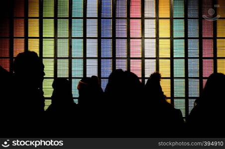 Silhouettes of people in candy store against a wall of chocolate bars