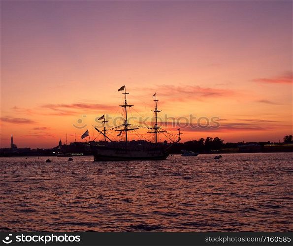 Silhouettes of ships in the waters of the Neva river at sunset. Silhouettes of ships on a sunset background